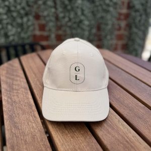 Sand Griffith Leagues Club cap with GL logo on timber table
